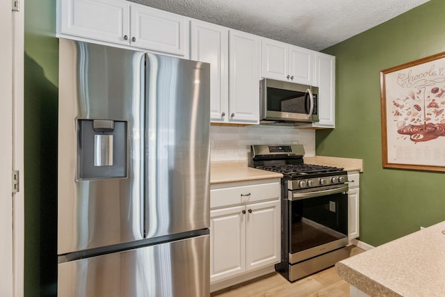 4109 Blendon Way Dr Unit 99E, Columbus, OH 43230 - kitchen with stainless steel appliances, light countertops, white cabinetry, light wood-style floors, and backsplash