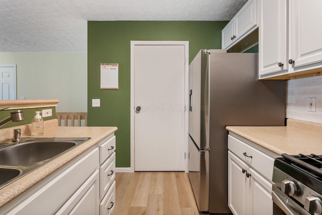 4109 Blendon Way Dr Unit 99E, Columbus, OH 43230 - kitchen with light wood-style floors, a textured ceiling, white cabinetry, light countertops, and backsplash