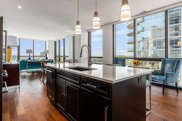 250 W Spring St Unit 626, Columbus, OH 43215 - kitchen with floor to ceiling windows, dishwashing machine, dark wood-style flooring, light countertops, and pendant lighting