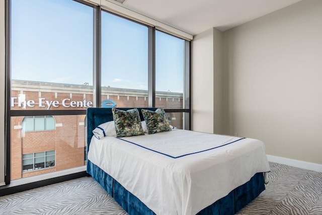 250 W Spring St Unit 626, Columbus, OH 43215 - carpeted bedroom with baseboards and a wall of windows
