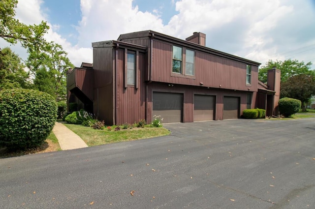 1206 Crescent Heights Rd, Marion, OH 43302 - view of front of house featuring a chimney, a garage, and asphalt driveway
