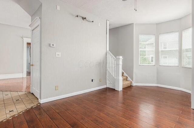 1364 E Fulton St, Columbus, OH 43205 - spare room featuring hardwood / wood-style flooring, stairway, and ceiling fan