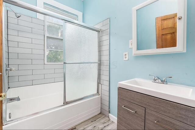 1364 E Fulton St, Columbus, OH 43205 - full bath with healthy amount of natural light, vanity, combined bath / shower with glass door, and wood finished floors