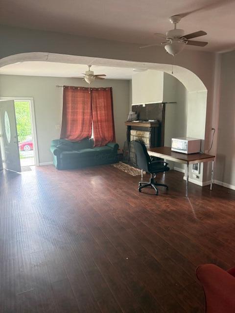 1364 E Fulton St, Columbus, OH 43205 - home office featuring arched walkways, ceiling fan, wood finished floors, and a stone fireplace