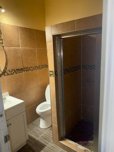 1364 E Fulton St, Columbus, OH 43205 - bathroom with tile walls, vanity, a shower stall, and tile patterned floors