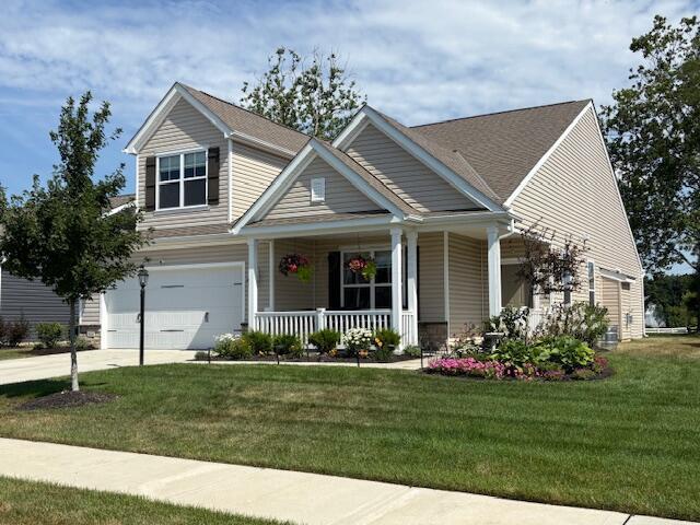 322 Blue Ridge Ct, Ostrander, OH 43061 - view of front of house with a porch, a garage, a front lawn, and concrete driveway