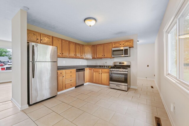 893 Aladdin Ct, Columbus, OH 43207 - kitchen with appliances with stainless steel finishes, dark countertops, and light tile patterned flooring