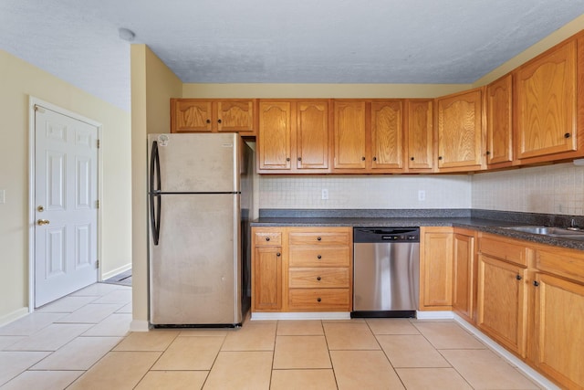 893 Aladdin Ct, Columbus, OH 43207 - kitchen with appliances with stainless steel finishes, decorative backsplash, light tile patterned floors, and dark countertops