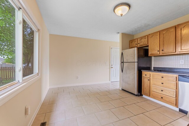 893 Aladdin Ct, Columbus, OH 43207 - kitchen with appliances with stainless steel finishes, dark countertops, backsplash, and light tile patterned floors