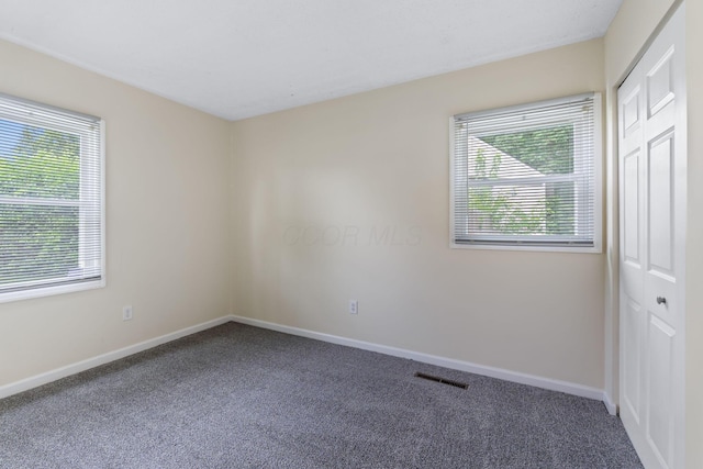 893 Aladdin Ct, Columbus, OH 43207 - unfurnished bedroom with carpet floors, multiple windows, and a closet