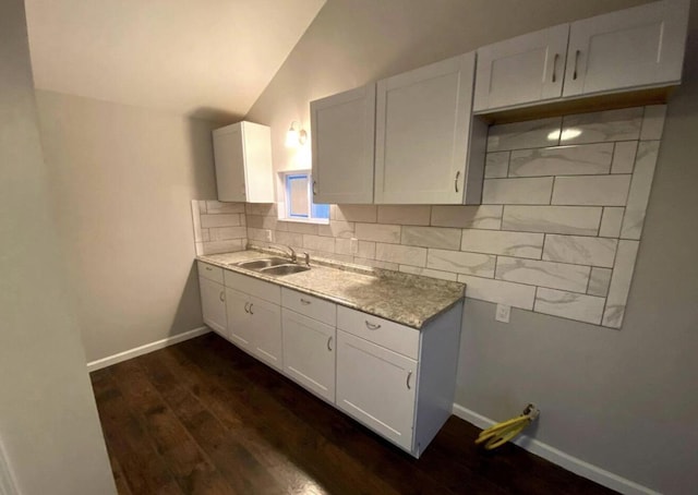 1555 Myrtle Ave, Columbus, OH 43211 - kitchen featuring dark wood-style flooring, light countertops, lofted ceiling, backsplash, and white cabinets