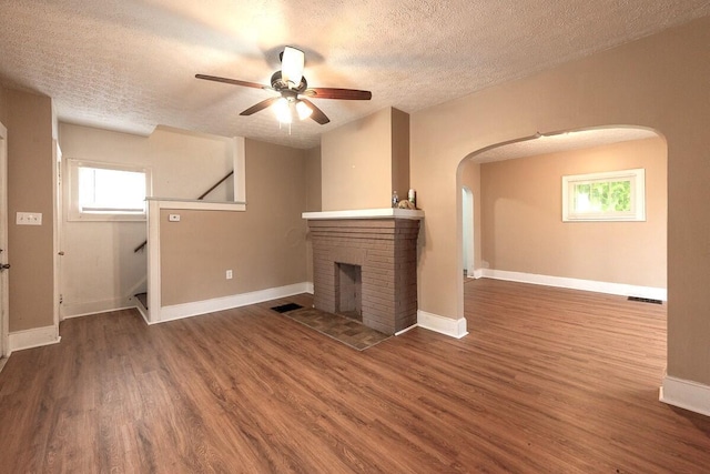 330 S Harris Ave, Columbus, OH 43204 - unfurnished living room featuring arched walkways, a textured ceiling, wood finished floors, ceiling fan, and stairs