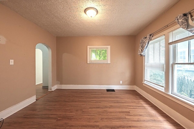 330 S Harris Ave, Columbus, OH 43204 - empty room featuring arched walkways, a textured ceiling, and dark wood-style flooring