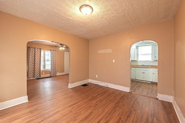 330 S Harris Ave, Columbus, OH 43204 - empty room with arched walkways, wood finished floors, a textured ceiling, and ceiling fan