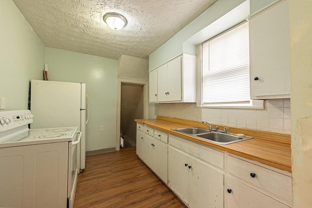 330 S Harris Ave, Columbus, OH 43204 - kitchen with white electric range, wood finished floors, a textured ceiling, backsplash, and white cabinetry