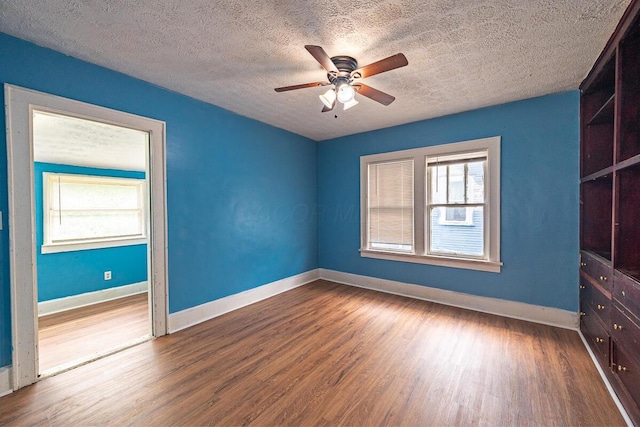 330 S Harris Ave, Columbus, OH 43204 - unfurnished bedroom featuring a textured ceiling, wood finished floors, multiple windows, and a ceiling fan