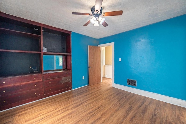 330 S Harris Ave, Columbus, OH 43204 - unfurnished bedroom with a textured ceiling, wood finished floors, and a ceiling fan