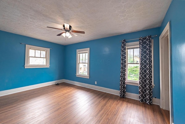 330 S Harris Ave, Columbus, OH 43204 - unfurnished room featuring a textured ceiling, plenty of natural light, wood finished floors, and a ceiling fan
