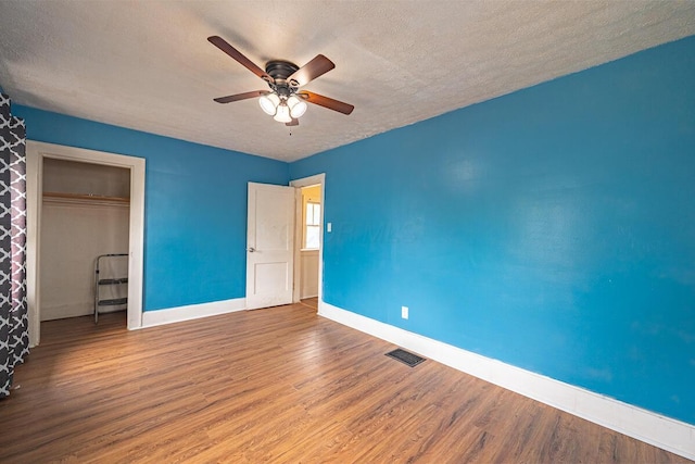 330 S Harris Ave, Columbus, OH 43204 - unfurnished bedroom featuring wood finished floors, a textured ceiling, a closet, and a ceiling fan