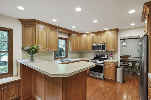 1100 Riva Ridge Blvd, Columbus, OH 43230 - kitchen with stainless steel appliances, a peninsula, light countertops, wood finished floors, and recessed lighting