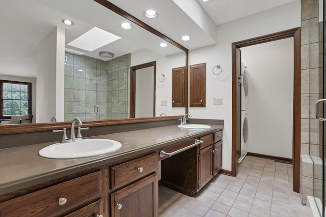 1100 Riva Ridge Blvd, Columbus, OH 43230 - full bathroom with stacked washing machine and dryer, a skylight, double vanity, a stall shower, and recessed lighting