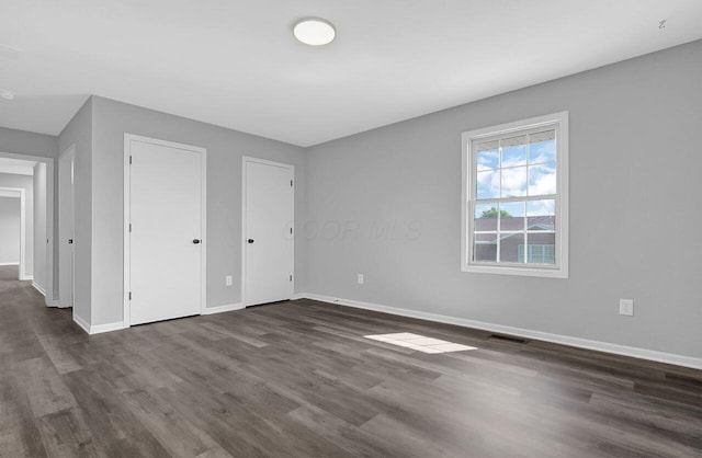 406 Aarika Dr, West Jefferson, OH 43162 - unfurnished bedroom with dark wood-type flooring and multiple closets