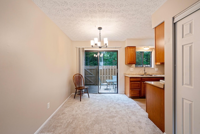 3033 Highcliff Ct, Columbus, OH 43231 - kitchen with a chandelier, brown cabinets, light countertops, light colored carpet, and a textured ceiling
