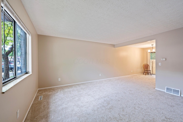 3033 Highcliff Ct, Columbus, OH 43231 - spare room featuring carpet flooring, a textured ceiling, and a chandelier