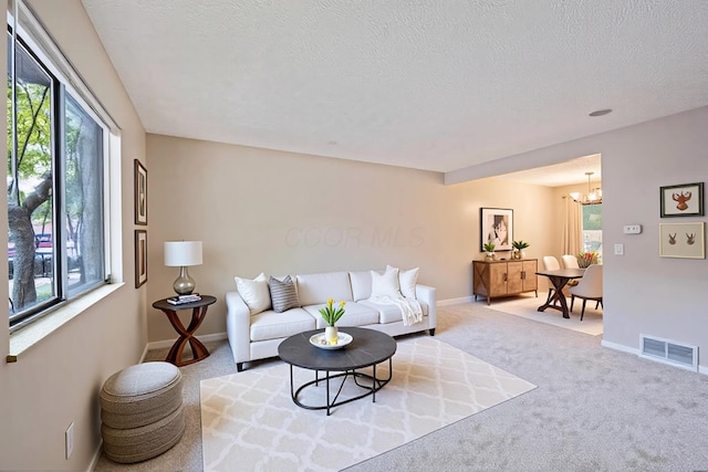 3033 Highcliff Ct, Columbus, OH 43231 - carpeted living area featuring a chandelier and a textured ceiling