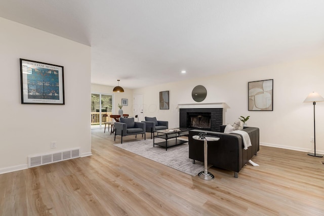 13900 Justin Rd, Utica, OH 43080 - living area featuring light wood-style floors, a brick fireplace, and recessed lighting