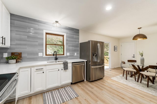 13900 Justin Rd, Utica, OH 43080 - kitchen with stainless steel appliances, tasteful backsplash, white cabinets, light countertops, and light wood-style flooring