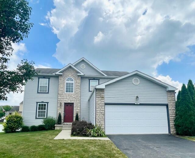 105 Yukon Dr, Commercial Point, OH 43116 - view of front of property featuring stone siding, driveway, a front lawn, and an attached garage