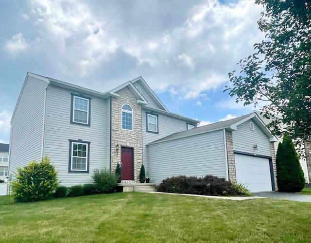105 Yukon Dr, Commercial Point, OH 43116 - view of front facade featuring stone siding, a front lawn, and driveway