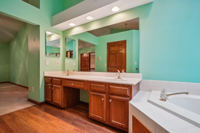 4867 Sarasota Ct, Hilliard, OH 43026 - bathroom featuring wood finished floors, double vanity, a garden tub, and recessed lighting