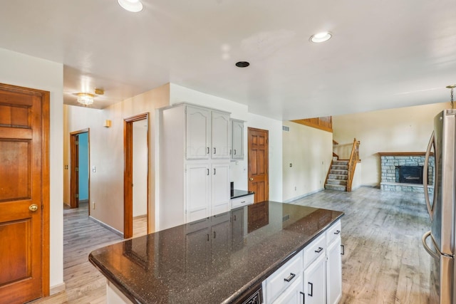 4867 Sarasota Ct, Hilliard, OH 43026 - kitchen with freestanding refrigerator, light wood-style floors, a kitchen island, open floor plan, and white cabinetry
