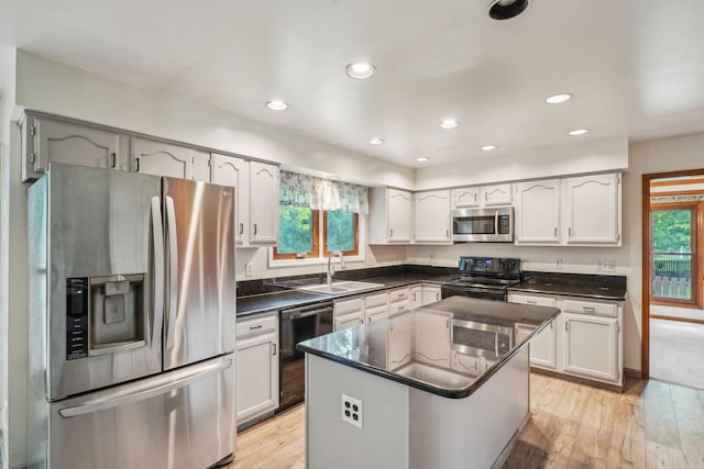 4867 Sarasota Ct, Hilliard, OH 43026 - kitchen featuring black appliances, light wood-style flooring, a center island, recessed lighting, and white cabinets