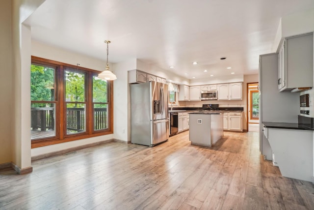 4867 Sarasota Ct, Hilliard, OH 43026 - kitchen with stainless steel appliances, dark countertops, a center island, light wood finished floors, and recessed lighting