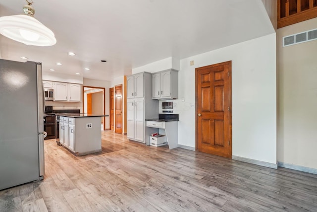 4867 Sarasota Ct, Hilliard, OH 43026 - kitchen featuring appliances with stainless steel finishes, dark countertops, light wood-style floors, recessed lighting, and a center island