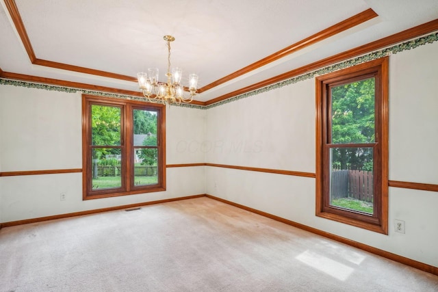 4867 Sarasota Ct, Hilliard, OH 43026 - carpeted empty room with a tray ceiling, ornamental molding, and a chandelier