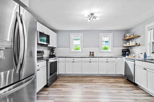 114 N 7th St, Newark, OH 43055 - kitchen featuring stainless steel appliances, decorative backsplash, white cabinets, and light wood finished floors
