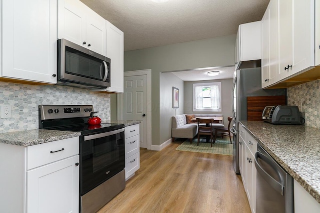 2686 Wicklow Rd, Columbus, OH 43204 - kitchen with stainless steel appliances, light wood-style flooring, white cabinets, and a textured ceiling