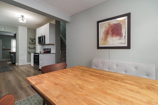 2686 Wicklow Rd, Columbus, OH 43204 - dining room featuring dark wood-style floors, stairs, and a textured ceiling