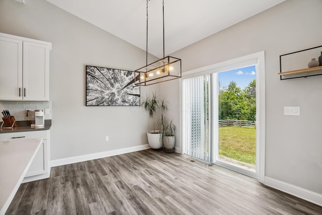 25500 Storms Rd, West Mansfield, OH 43358 - unfurnished dining area with wood finished floors, vaulted ceiling, and a chandelier