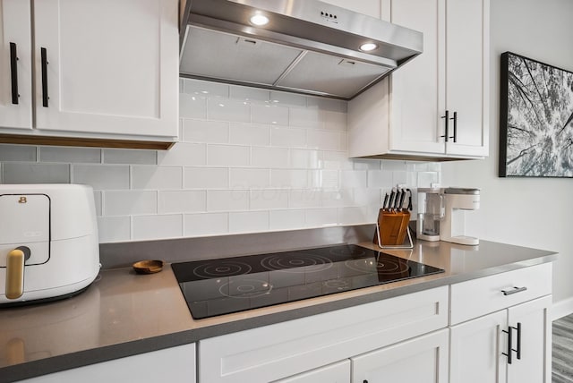25500 Storms Rd, West Mansfield, OH 43358 - kitchen with extractor fan, black electric stovetop, white cabinetry, and backsplash