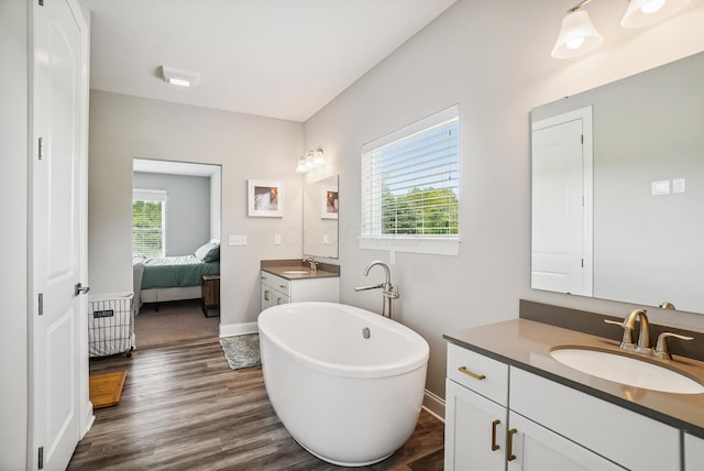 25500 Storms Rd, West Mansfield, OH 43358 - bathroom with a soaking tub, two vanities, connected bathroom, and wood finished floors