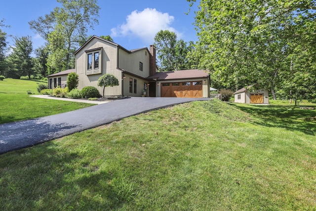 680 Rainbow Dr NW, Lancaster, OH 43130 - view of front of house with an attached garage, asphalt driveway, a chimney, a front lawn, and an outdoor structure