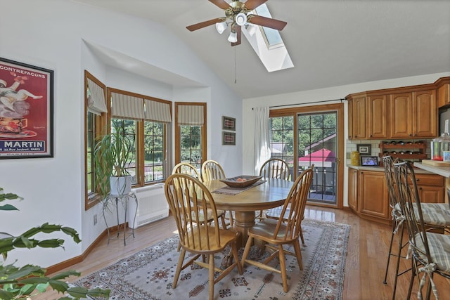 680 Rainbow Dr NW, Lancaster, OH 43130 - dining area with ceiling fan, a skylight, vaulted ceiling, plenty of natural light, and light wood-style flooring