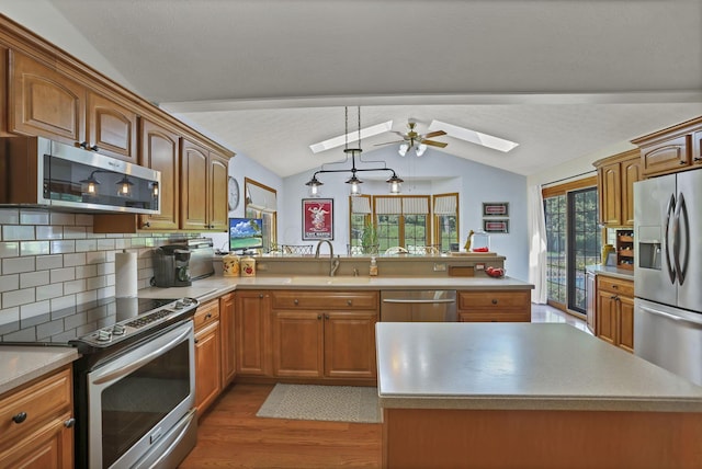 680 Rainbow Dr NW, Lancaster, OH 43130 - kitchen with stainless steel appliances, vaulted ceiling, a skylight, wood finished floors, and decorative backsplash