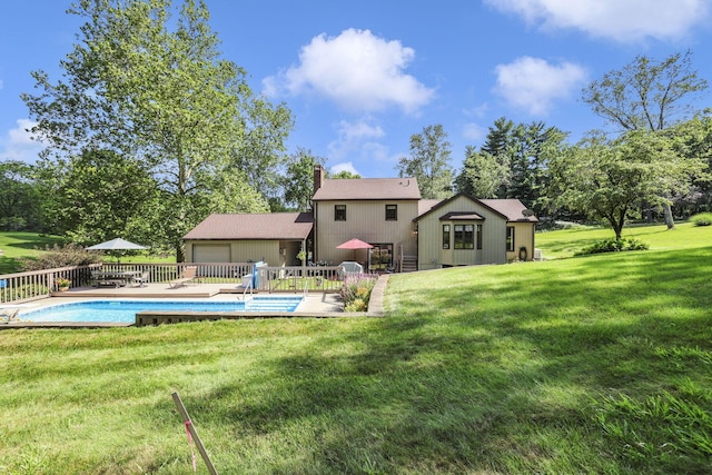 680 Rainbow Dr NW, Lancaster, OH 43130 - back of property featuring a yard, a chimney, an attached garage, a wooden deck, and view of wooded area