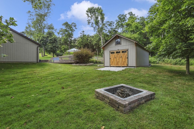 680 Rainbow Dr NW, Lancaster, OH 43130 - view of green lawn with a fire pit and an outbuilding